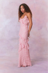 Designed with elegance and movement in mind, the Rialto Maxi Dress in Strawberry Macaroon captivates with its chiffon fabric and cascading asymmetrical ruffles that flow from neckline to hem. Its slightly fitted silhouette enhances your figure with subtle allure, while a discreet side seam zipper ensures a seamless fit. Perfect for dancing or any refined occasion, this dress combines comfort with sophisticated style effortlessly.