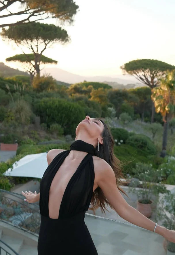 The Amber Maxi Dress by Helsa Studio combines refined elegance with bold design. Featuring a sculpted silhouette and delicate draping, it flatters the figure while the halter neckline and sheer scarf add refined sophistication. The flared hem enhances graceful movement, complemented by a sheer bodice that introduces a confident, modern edge. Perfect for special occasions, this dress delivers a distinctive and memorable style with expert craftsmanship.