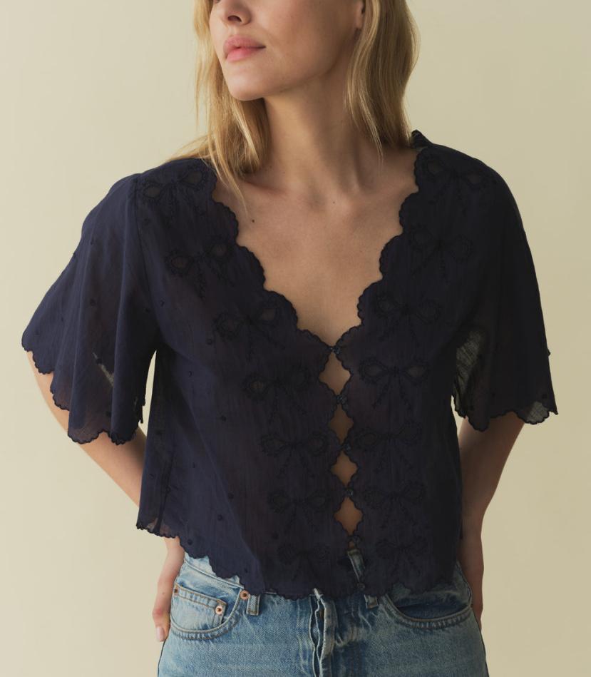 Indulge in the romantic charm of the Kacy Embroidered Top by DOEN, crafted with 100% organic cotton voile and adorned with delicate bow embroidery and playful cutouts. Inspired by vintage Victorian blouses, this top features elegant scalloped details and breezy sleeves that add a touch of sophistication. Elevate your wardrobe with this luxurious and exclusive piece.