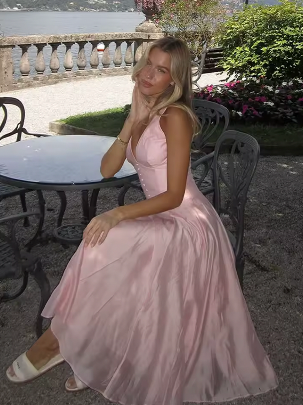 Crafted from lightweight pink chiffon, the 'Samira' midi dress combines elegance with effortless movement. Its classic V-neckline and signature boning offer a tailored silhouette that flatters the bust and defines the waist. Front buttons enhance the refined fit, while subtle pleats in the skirt create graceful flow, adapting naturally to your movements. Designed to leave a lasting impression, this dress exemplifies sophisticated style with expert attention to detail.