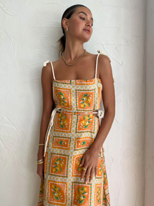 Embrace the essence of a Sicilian summer with the Lemonade Tie Maxi Dress in Orange Mosaic. Made from a breathable linen-cotton blend and fully lined, this dress offers comfort through long summer days. Its straight neckline and fitted bodice flatter the silhouette, while adjustable rope shoulder and waist ties provide a personalized fit. 