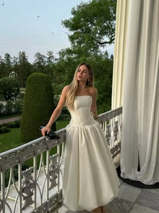 The Chateau Midi Dress combines timeless elegance with modern design, featuring a solid, strapless bodice and an A-line silhouette that flatters every figure. Its high waist and pleated skirt create a refined, flowing shape, perfect for summer events and sophisticated parties. Crafted to ensure comfort without sacrificing style, this chic sleeveless dress is an ideal choice for women seeking effortless grace in warm weather.