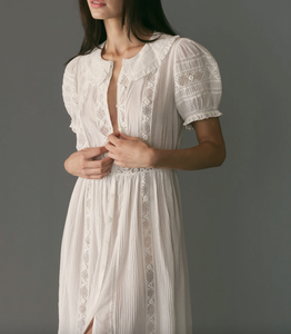 Indulge in timeless elegance with our Phoebe Lace Dress. Made from the softest organic cotton voile, it features delicate pintucks, inset lace, and a ruffled Peter Pan collar for a Victorian-inspired look. The fitted waist and mother-of-pearl buttons add a touch of sophistication, making it perfect for any occasion.