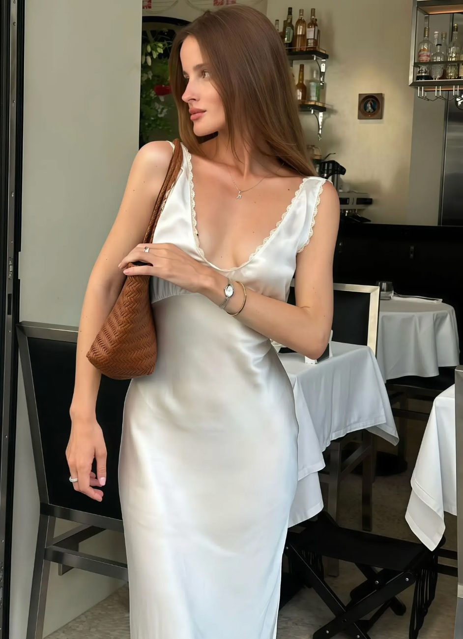 Elevate your evening look with the Allegra Satin Dress, a sleeveless, slim-fit gown designed to flatter your silhouette. Crafted from smooth satin, it features an elegant lace V-neckline and a high waist that enhances your figure. Perfect for sophisticated parties and special occasions, this dress combines timeless style with a touch of sensuality for a truly captivating presence.