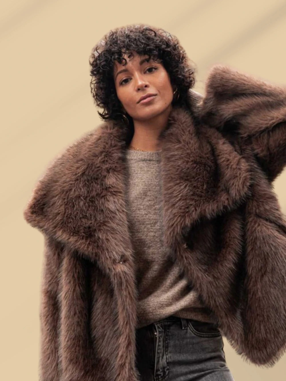 This short faux fur coat combines sophisticated style with practical details. Designed with a classic lapel collar and long sleeves, it offers warmth and elegance. Side pockets add convenience, while the tonal lining ensures a smooth fit. The front fastening with metal hooks provides secure closure and a sleek finish, making it an ideal choice for refined winter wear.