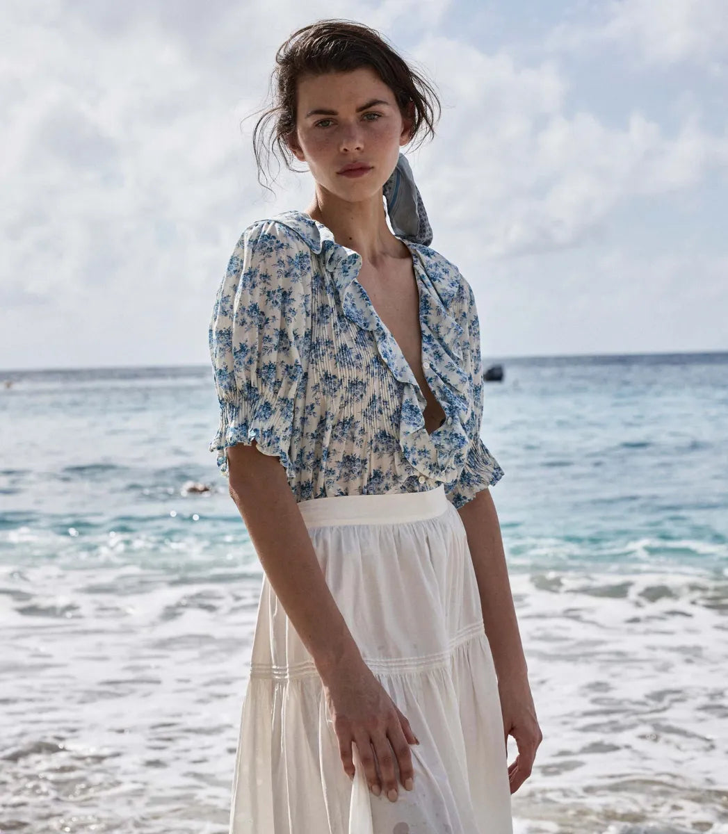 The Henri top in Bleu Rosier Floral offers a refined yet approachable style, crafted from soft fabric adorned with a delicate blue floral pattern. Its subtle ruffle detail and V-neckline enhance the rustic charm while the gently fitted silhouette flatters the figure. Pair it effortlessly with blue denim for versatile looks that transition seamlessly from casual daywear to polished evening ensembles with the right footwear choice.