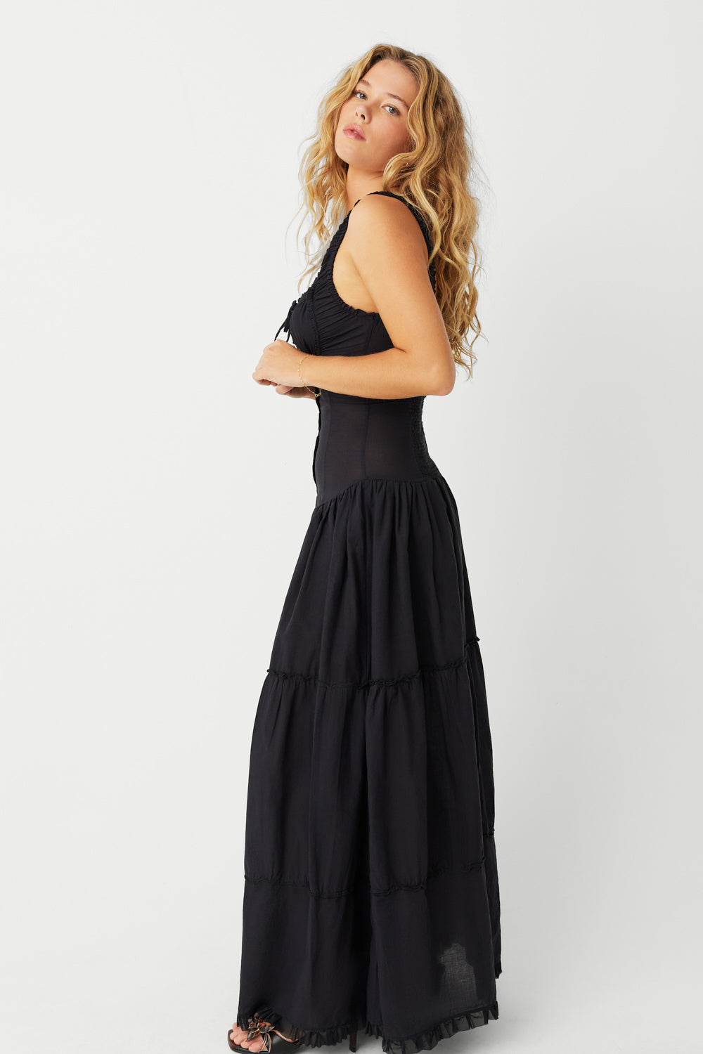 The Christabelle Dress in Black is the perfect addition to your spring wardrobe. Designed with smocking details and ruffle accents, this maxi dress exudes a feminine and playful look. With fixed buttons and a prairie silhouette, it's both stylish and comfortable. Slip into it and your favorite pair of pumps for the ultimate weekend outfit.