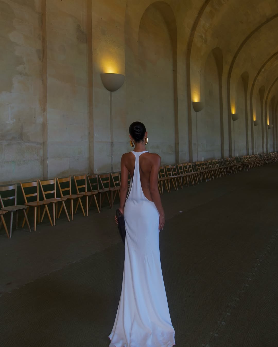 The Marcel dress by Jacquemus exudes elegance with its floor-length mermaid silhouette crafted from stretch crepe for a flattering fit. Featuring delicate chiffon lining and a racerback design, it showcases sophisticated triangle cutouts and bias-cut details at the front, creating a refined and captivating look for any special occasion.