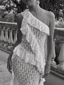 Elevate your wardrobe with the Asymmetric Lace Set, designed for those who appreciate refined elegance. The high-waisted semi-sheer long skirt ensures a comfortable fit thanks to its elastic waistband, while the semi-sheer top features an asymmetric neckline and delicate ruffle accents that add a sophisticated edge. This ensemble seamlessly blends subtle allure with comfort, making it an ideal choice for sophisticated occasions where impeccable style is paramount.