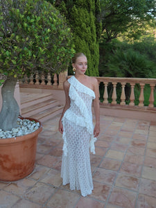 Elevate your wardrobe with the Asymmetric Lace Set, designed for those who appreciate refined elegance. The high-waisted semi-sheer long skirt ensures a comfortable fit thanks to its elastic waistband, while the semi-sheer top features an asymmetric neckline and delicate ruffle accents that add a sophisticated edge. This ensemble seamlessly blends subtle allure with comfort, making it an ideal choice for sophisticated occasions where impeccable style is paramount.