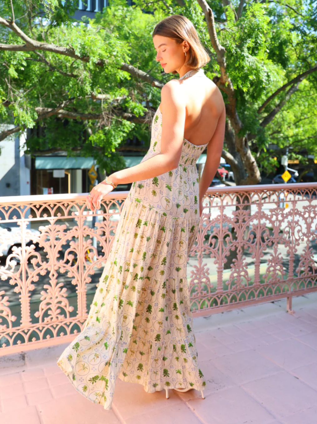 Embrace effortless summer elegance with the Palm Noosa Willow Dress in Tropical Palms. This midi silhouette combines a sophisticated halter neckline with a sculpted bodice and cinched waist that gracefully transitions into a voluminous skirt. Constructed from premium linen, the fabric breathes beautifully in warm weather while maintaining its refined drape. 