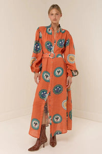The Noddy Dress in Orange Plates by Palm Noosa showcases a refined midi silhouette crafted from 100% premium linen. Its relaxed fit is complemented by elegant blouson sleeves with elasticated cuffs, a sleek stand collar, and a button-front design. A matching buckle belt allows you to define your waist gracefully, enhancing the dress’s flattering drape. Perfect for an effortless yet polished look, this dress combines comfort and style with sophisticated ease. Please consult our size guide for the best fit.