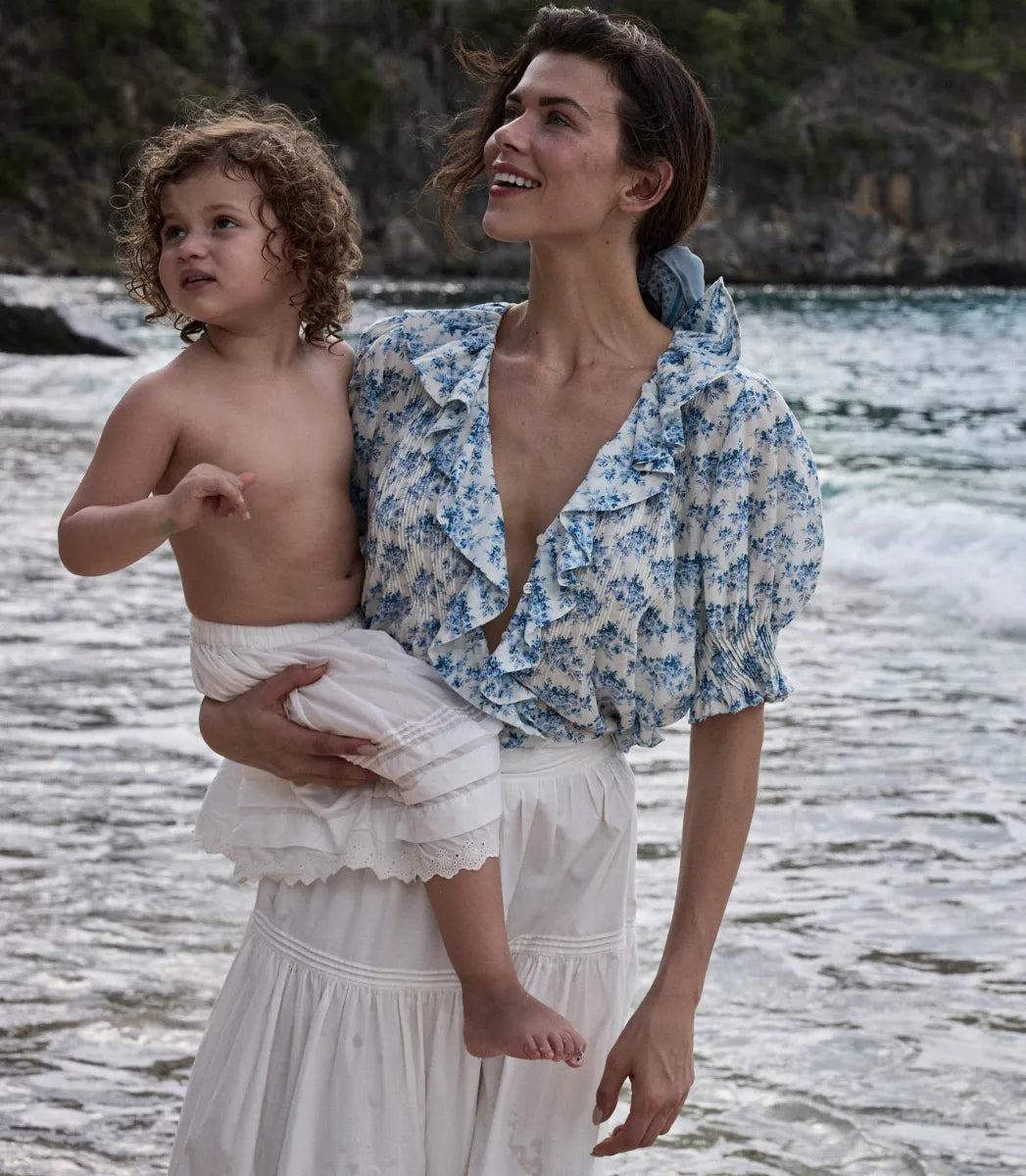 The Henri top in Bleu Rosier Floral offers a refined yet approachable style, crafted from soft fabric adorned with a delicate blue floral pattern. Its subtle ruffle detail and V-neckline enhance the rustic charm while the gently fitted silhouette flatters the figure. Pair it effortlessly with blue denim for versatile looks that transition seamlessly from casual daywear to polished evening ensembles with the right footwear choice.
