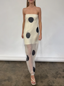 The Mila Maxi Dress in Ivory Polka by Nicole features sheer organza adorned with striking polka dots, shaping a sleek column silhouette. Its half-lined design and elasticated back ensure comfort and adaptability, while the option to wear it with or without straps provides versatile styling choices perfect for refined occasions.