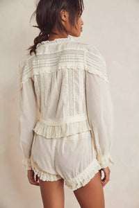 Embrace timeless elegance with the Florence Bed Jacket Set, designed for sophisticated comfort. The structured bed jacket features front tie closures, pleated details, banded trumpet sleeves, and delicate embroidery, offering a refined vintage appeal. Coordinating button-front shorts include a drawstring waist, ruffle trimming, pleated accents, and an embroidered curved hem, ensuring an effortless, flattering fit. This set blends classic style with ease, perfect for lounging with grace and poise.