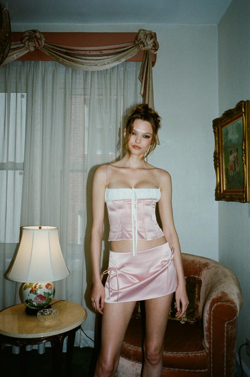 Discover effortless style with the Serena Mini Skirt by With Jean. This low rise, mini length skirt is designed to sit comfortably on your hips, while the back zip closure provides a seamless finish. The cinched bow detailing at the front adds a touch of sophistication to your ensemble. Elevate your look with this luxurious piece.