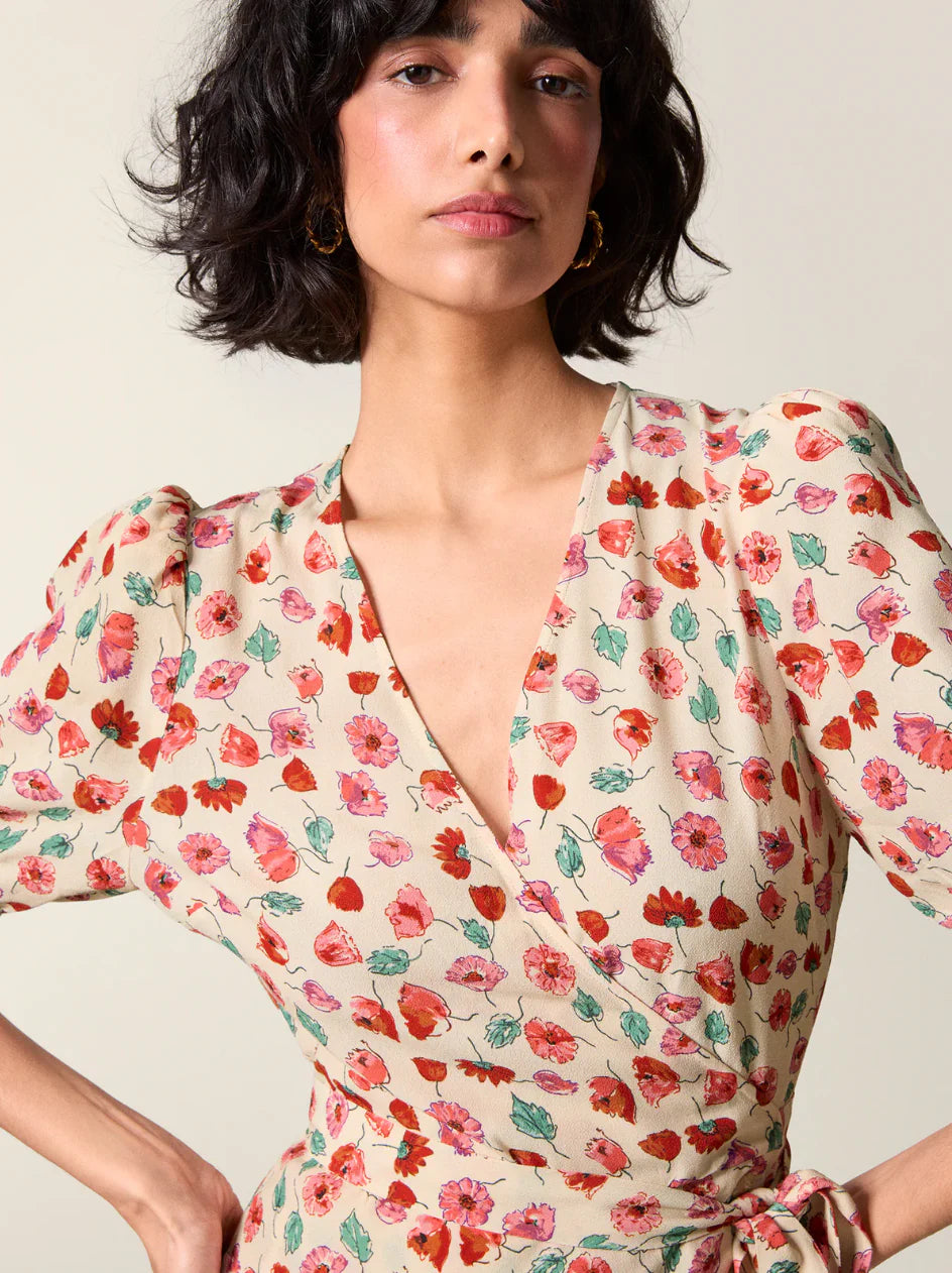 La robe portefeuille midi Rosalina se distingue par son imprimé wildflowers beige délicat. Dotée d’un décolleté en V cache-coeur et de manches courtes avec fronces aux épaules, elle offre une silhouette élégante et ajustée. Les boutons en nacre véritable apportent une touche raffinée, tandis que le large lien de serrage permet un maintien personnalisé. Des pinces soigneusement placées dans le haut du dos assurent un tombé impeccable et un confort optimal. 