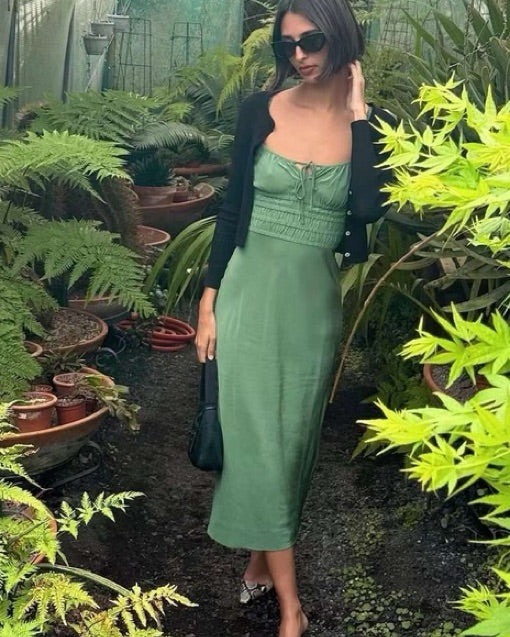 The Camille in Poison by Realisation Par blends chic minimalism with versatile design. Crafted from solid-colored silk, it features a milk-maid style bust with a keyhole detail that can be tied for added lift or left untied for a relaxed, elegant look. The form-fitting elasticated torso and back, adjustable straps, and bias-cut skirt ensure a flattering fit on various body shapes. Pair with kitten heels to complete a sophisticated yet effortlessly alluring ensemble.
