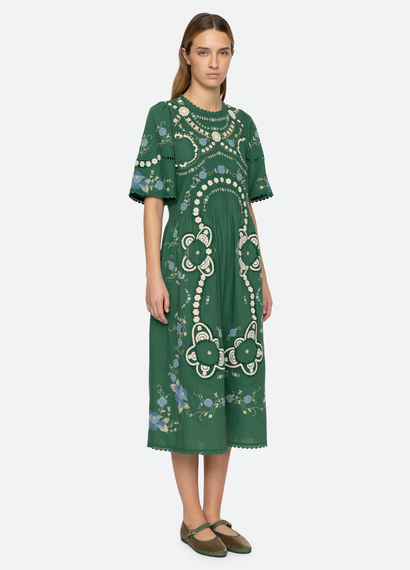 Elevate your wardrobe with the Vesna Embroidered Midi Dress by SEA NY, featuring delicate embroidery and scalloped trim for a refined finish. Its crew neckline and short sleeves complement the flattering A-line silhouette, while the hem gracefully falls below the knee. The back tie closure offers a tailored fit, combining elegance with comfort. Crafted from a cotton, linen, and polyester blend, this dress is best maintained with dry cleaning to preserve its quality. Perfect for sophisticated occasions.