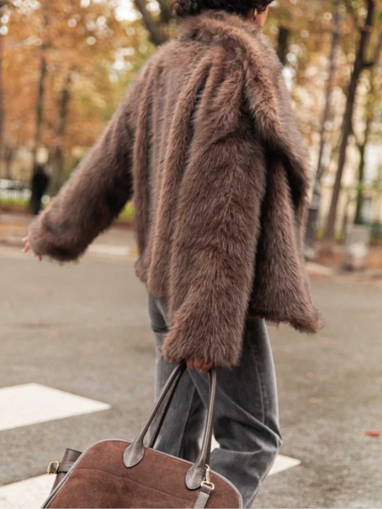 This short faux fur coat combines sophisticated style with practical details. Designed with a classic lapel collar and long sleeves, it offers warmth and elegance. Side pockets add convenience, while the tonal lining ensures a smooth fit. The front fastening with metal hooks provides secure closure and a sleek finish, making it an ideal choice for refined winter wear.