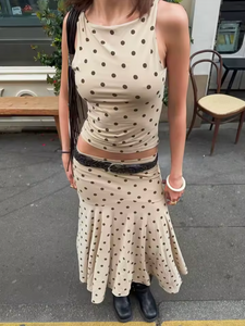 The Maeve Set by With Jean combines a low rise, midi-length skirt with a slim fit, high neck longline top, both adorned with a distinctive custom polka dot print. The skirt’s design ensures a flattering fit on the hips, while the top offers a sleek silhouette that complements the look, making this set a refined choice for a modern, polished wardrobe.
