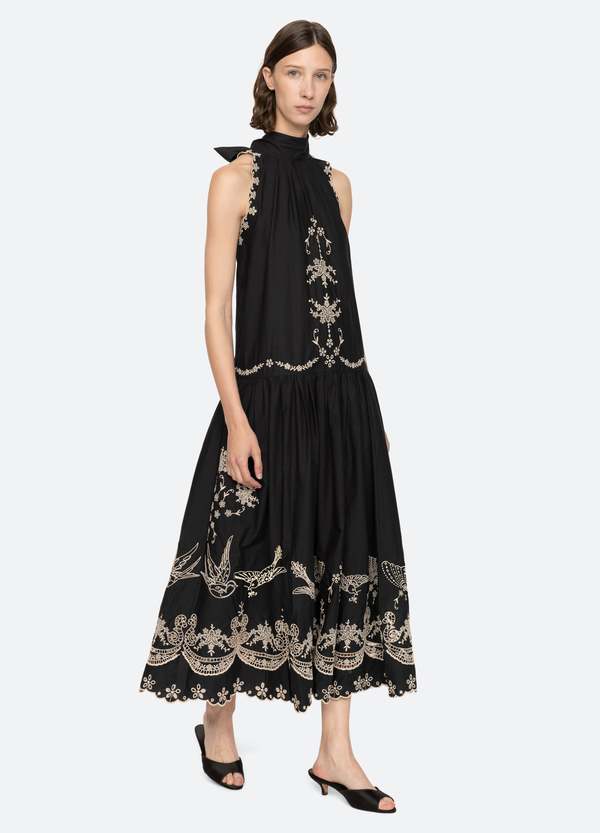 The Kingsley embroidered tank dress by SEA NY showcases intricate embroidery throughout its design, offering a refined and elegant appeal. It features a high neckline that adds a sophisticated touch, complemented by a delicate back bow tie for adjustable fit and added charm. The scalloped hemline enhances the dress's feminine silhouette, making it an exceptional choice for those seeking a polished yet distinctive look.