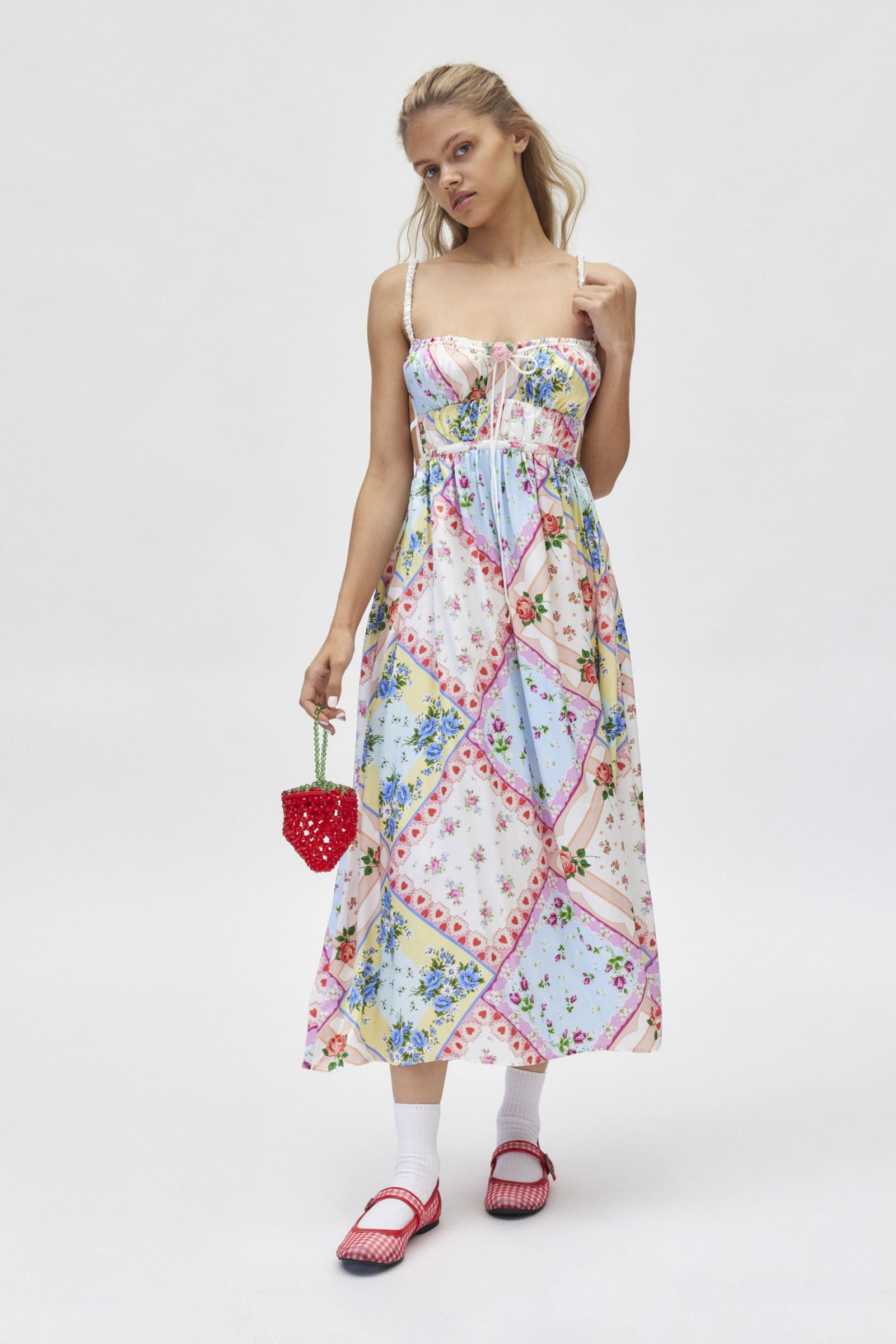 The Cassandra Dress by For Love & Lemons offers a chic and sophisticated look with its midi length, square neckline, and open back design. Its silky, patchwork quilted fabric adds texture and interest, while the fitted bodice with rose detail and double back ties create a flattering silhouette. Perfect for any occasion, with adjustable closures for a customizable fit.