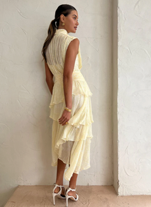 Introducing the Gina Sleeveless Ruched Midi Dress in Limoncello - a must-have for any special occasion. Crafted from semi-sheer chiffon, this dress boasts a high neck and adjustable rouleau straps for a perfect fit. With its fitted waist and asymmetrical tiered skirt, this dress exudes elegance and style. Perfect for formal events and celebrations.