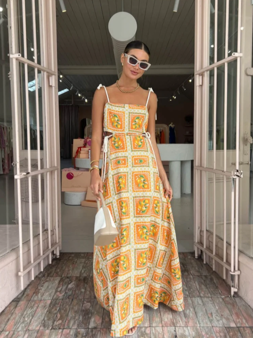 Embrace the essence of a Sicilian summer with the Lemonade Tie Maxi Dress in Orange Mosaic. Made from a breathable linen-cotton blend and fully lined, this dress offers comfort through long summer days. Its straight neckline and fitted bodice flatter the silhouette, while adjustable rope shoulder and waist ties provide a personalized fit. 