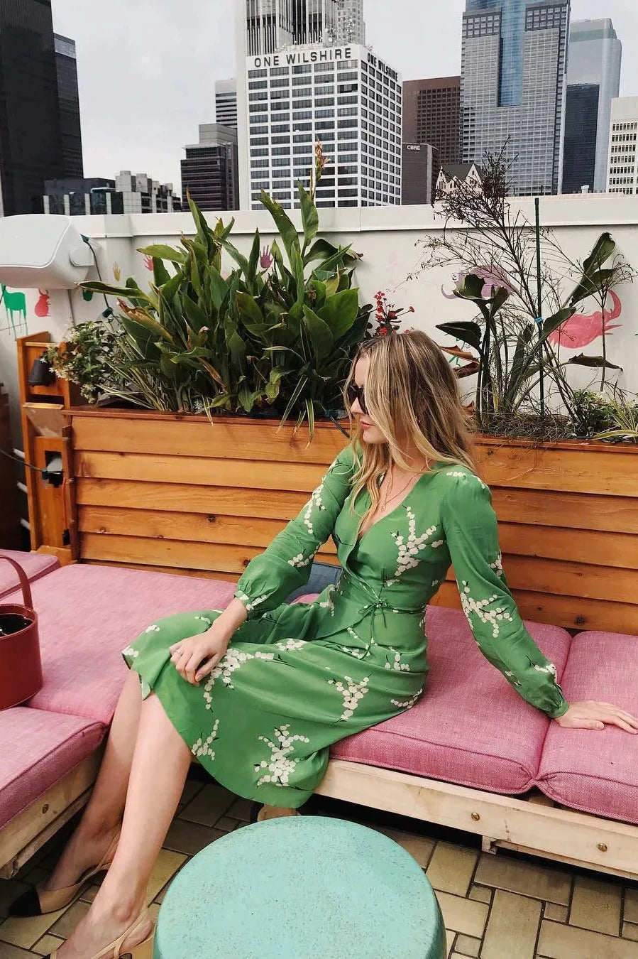 Show off your playful side in the Violette Midi Dress! This stunning lightweight silk dress features a white floral print on a vibrant green background. With 3/4 length sleeves and a comfortable wrap style, you can adjust the waist with the string tie closure. Embrace your love for summer in this unique and stylish dress!