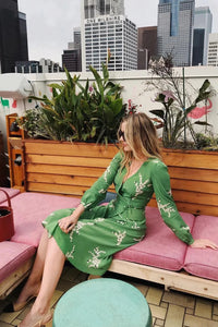 Show off your playful side in the Violette Midi Dress! This stunning lightweight silk dress features a white floral print on a vibrant green background. With 3/4 length sleeves and a comfortable wrap style, you can adjust the waist with the string tie closure. Embrace your love for summer in this unique and stylish dress!