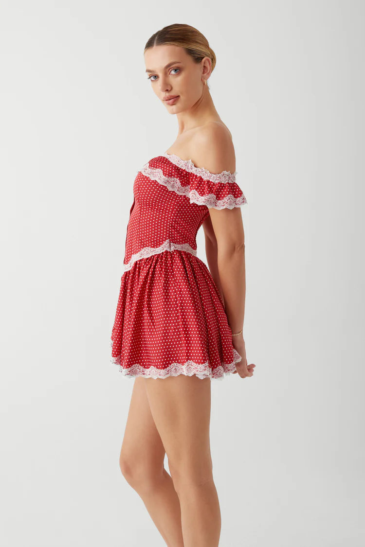 Elevate your evening look with the Charli Mini Dress in Scarlet Dot by Frankies Bikinis. Made of silk-like fabric, this off-the-shoulder dress features a smocked back and corset waist for a sultry silhouette. Vintage-inspired lace accents and lace trim add a touch of elegance, while the elastic neckline ensures a comfortable fit. Perfect for any special occasion.