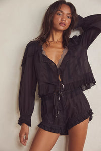 Experience timeless elegance with the Florence Set in Black, designed for both comfort and style. The structured bed jacket features front tie closures, delicate pleated piecing, and banded trumpet sleeves accented by intricate embroidery and ruffle trim. Coordinating shorts offer a drawstring waist for a customizable fit, complemented by ruffle details, pleated patterns, and embroidered accents with a graceful curved hem. Perfect for lounging with refined sophistication.