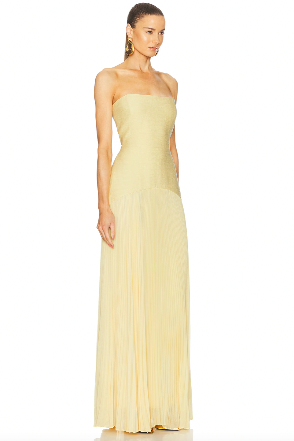 The Sunniva Dress features a fitted strapless bodice and a gracefully curved dropped waist that flows into a delicate plissé skirt. This elegant silhouette accentuates your figure while allowing ease of movement. Ideal for pairing with bold statement earrings, it creates a refined and modern look perfect for leaving a lasting impression at any event.