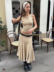 The Maeve Set by With Jean combines a low rise, midi-length skirt with a slim fit, high neck longline top, both adorned with a distinctive custom polka dot print. The skirt’s design ensures a flattering fit on the hips, while the top offers a sleek silhouette that complements the look, making this set a refined choice for a modern, polished wardrobe.