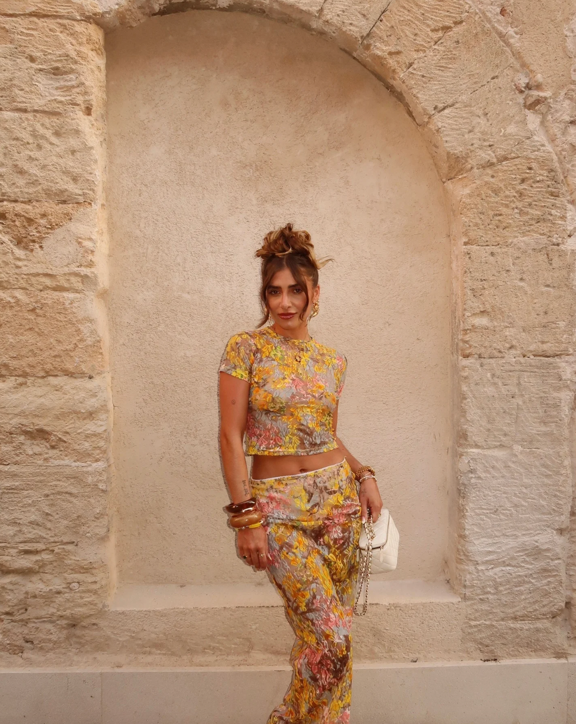 This elegant set features a multi-floral maxi skirt with a form-fitting silhouette that sits mid to low waist, crafted from luxurious stretchy lace for comfort and style. Complemented by a coordinating semi-sheer floral baby t-shirt with cap sleeves and a cropped shape, both pieces showcase a bright summer palette and timeless design, perfect for a sophisticated seasonal look.
