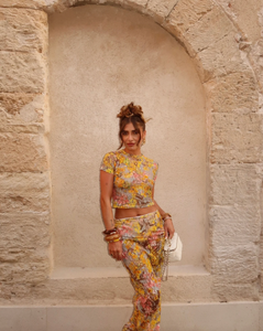 This elegant set features a multi-floral maxi skirt with a form-fitting silhouette that sits mid to low waist, crafted from luxurious stretchy lace for comfort and style. Complemented by a coordinating semi-sheer floral baby t-shirt with cap sleeves and a cropped shape, both pieces showcase a bright summer palette and timeless design, perfect for a sophisticated seasonal look.