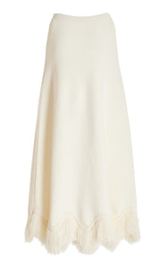 The 'Paulina' skirt offers a graceful A-line shape that gently widens toward its distinctive zig-zag fringe-trimmed hem. Complete the look by pairing it with the coordinating 'Koa' top, which boasts a sleek, sleeveless design accented by a matching zig-zag fringe detail at the hem.