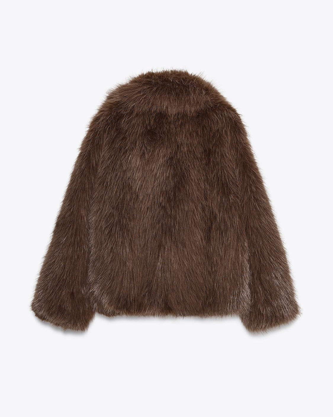 This short faux fur coat combines sophisticated style with practical details. Designed with a classic lapel collar and long sleeves, it offers warmth and elegance. Side pockets add convenience, while the tonal lining ensures a smooth fit. The front fastening with metal hooks provides secure closure and a sleek finish, making it an ideal choice for refined winter wear.