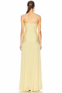 The Sunniva Dress features a fitted strapless bodice and a gracefully curved dropped waist that flows into a delicate plissé skirt. This elegant silhouette accentuates your figure while allowing ease of movement. Ideal for pairing with bold statement earrings, it creates a refined and modern look perfect for leaving a lasting impression at any event.