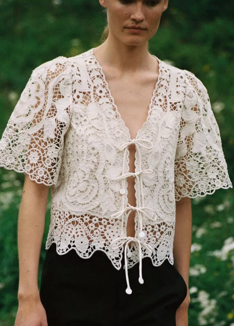 The Gianna Tie Top from Sea New York blends delicate lace detailing with a relaxed fit for effortless elegance. Crafted from 100% cotton with polyester embroidery, it features short flowy sleeves and a front tie closure, delivering both comfort and a romantic silhouette. Ideal for those seeking a refined yet easygoing style.