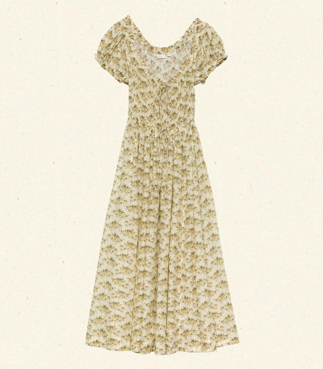 Crafted from soft, lightweight organic cotton voile, the Ashlynn Dress in Citron Rosier Floral by Doen blends Victorian elegance with modern comfort. Featuring short puffed sleeves, a scoop neckline with a functional center tie, and delicate ruffled cuffs, this dress exudes vintage charm. The smocked bodice ensures a flattering fit, complemented by an adjustable waist tie, while the full, ankle-grazing skirt offers graceful movement. Ideal for those seeking refined style with breathable, sustainable fabric.
