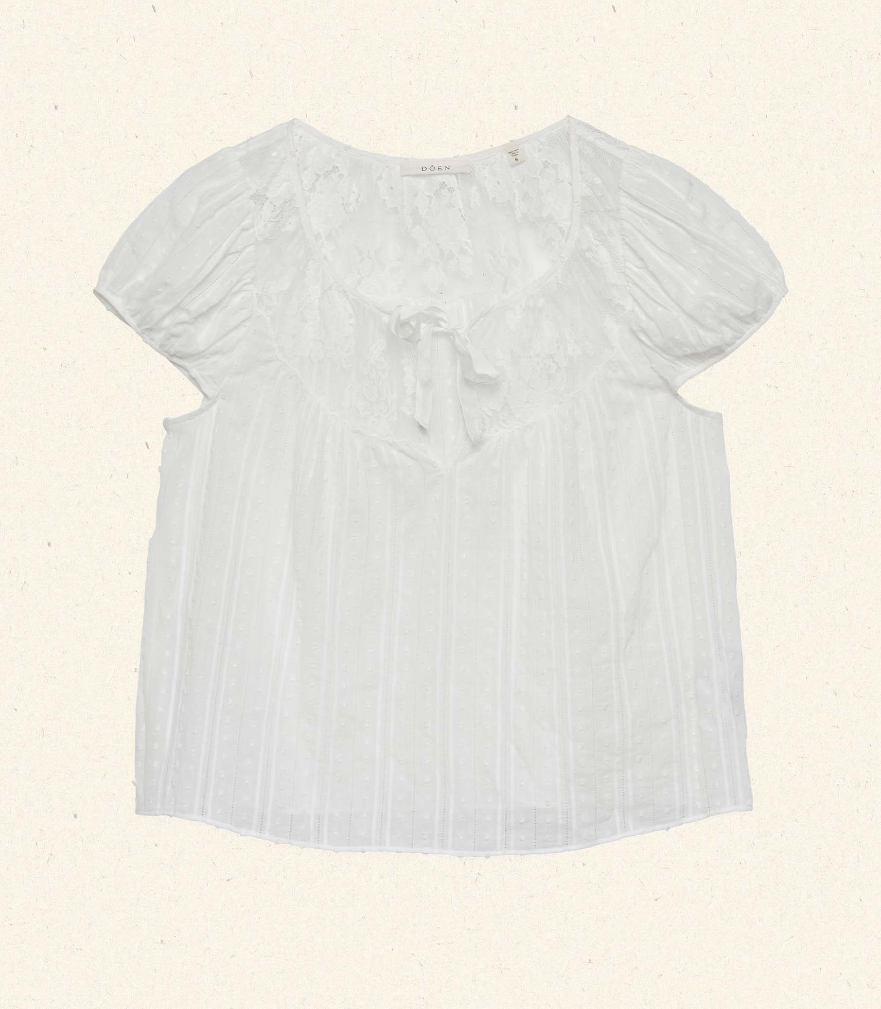 The DOEN Camri Top features a refined design with short sleeves and elegant tie detailing, offering a versatile and sophisticated look. Crafted for comfort and style, it pairs effortlessly with both casual and dressier outfits, making it an essential addition to your wardrobe.