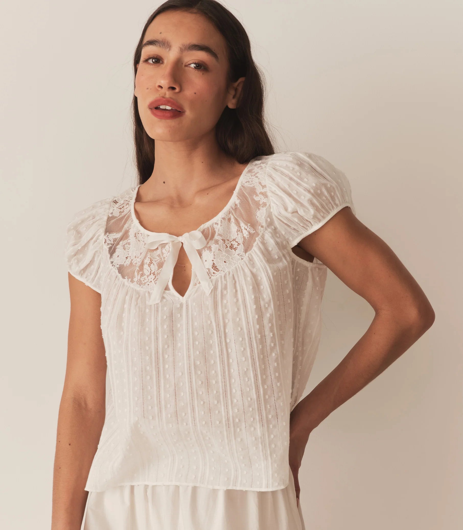 The DOEN Camri Top features a refined design with short sleeves and elegant tie detailing, offering a versatile and sophisticated look. Crafted for comfort and style, it pairs effortlessly with both casual and dressier outfits, making it an essential addition to your wardrobe.