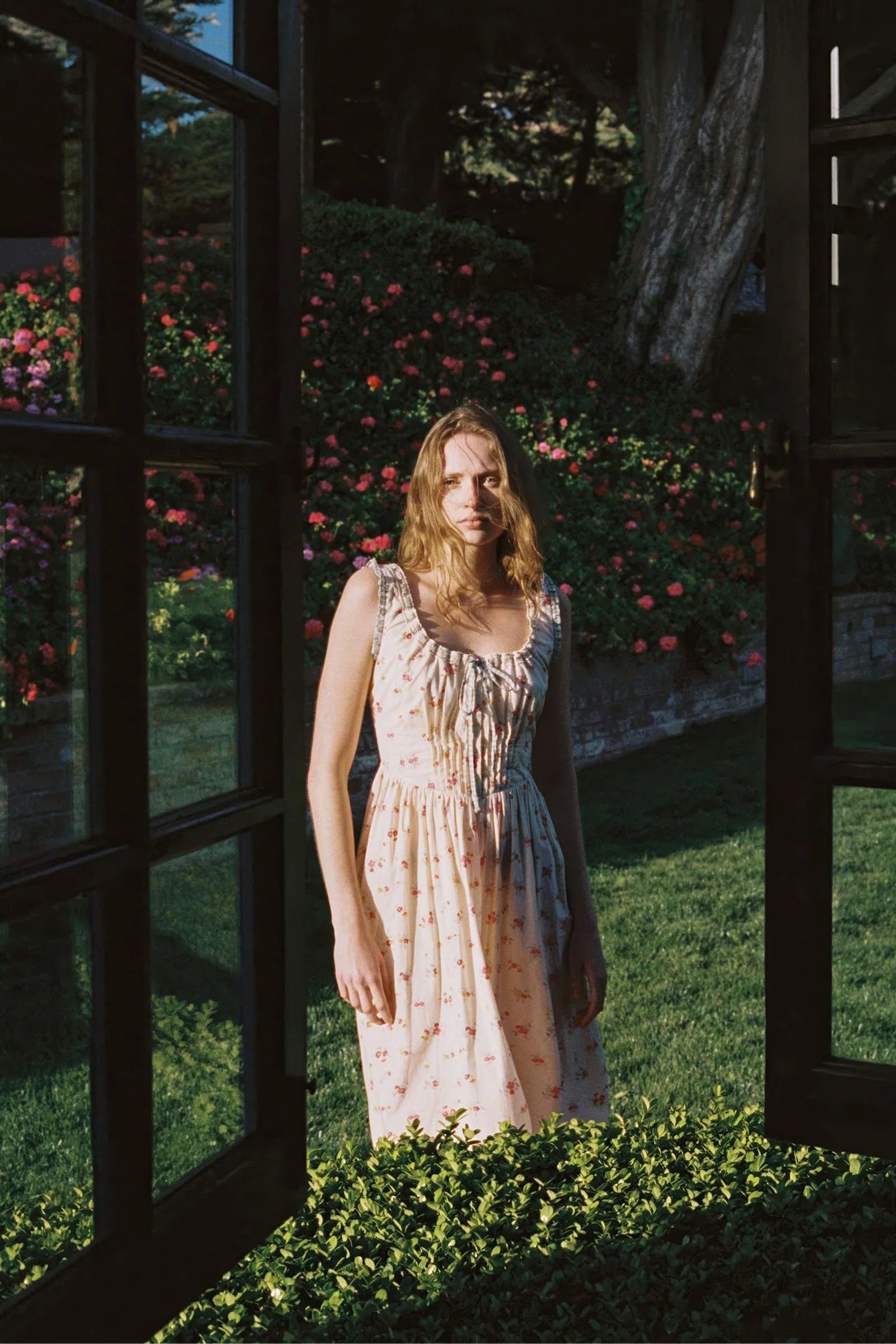 Inspired by Edwardian corsets, the Eliana Dress combines classic sophistication with contemporary ease. Made from 100% organic cotton, this sleeveless midi features an exaggerated wide scoop neckline adorned with contrasting eyelet trim and soft ruffles. A half-functional front button placket and subtle micro pintucks at the bust provide elegant accents, while the lace-up back creates a striking, form-fitting silhouette. 