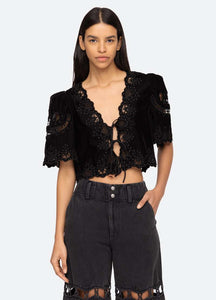 Introducing the Eliana Top by SEA, a luxurious piece adorned with intricate embroidery and a playful tie front. Its short, flowy sleeves add a touch of femininity. Elevate your style with this exclusive top that boasts elegance and sophistication.