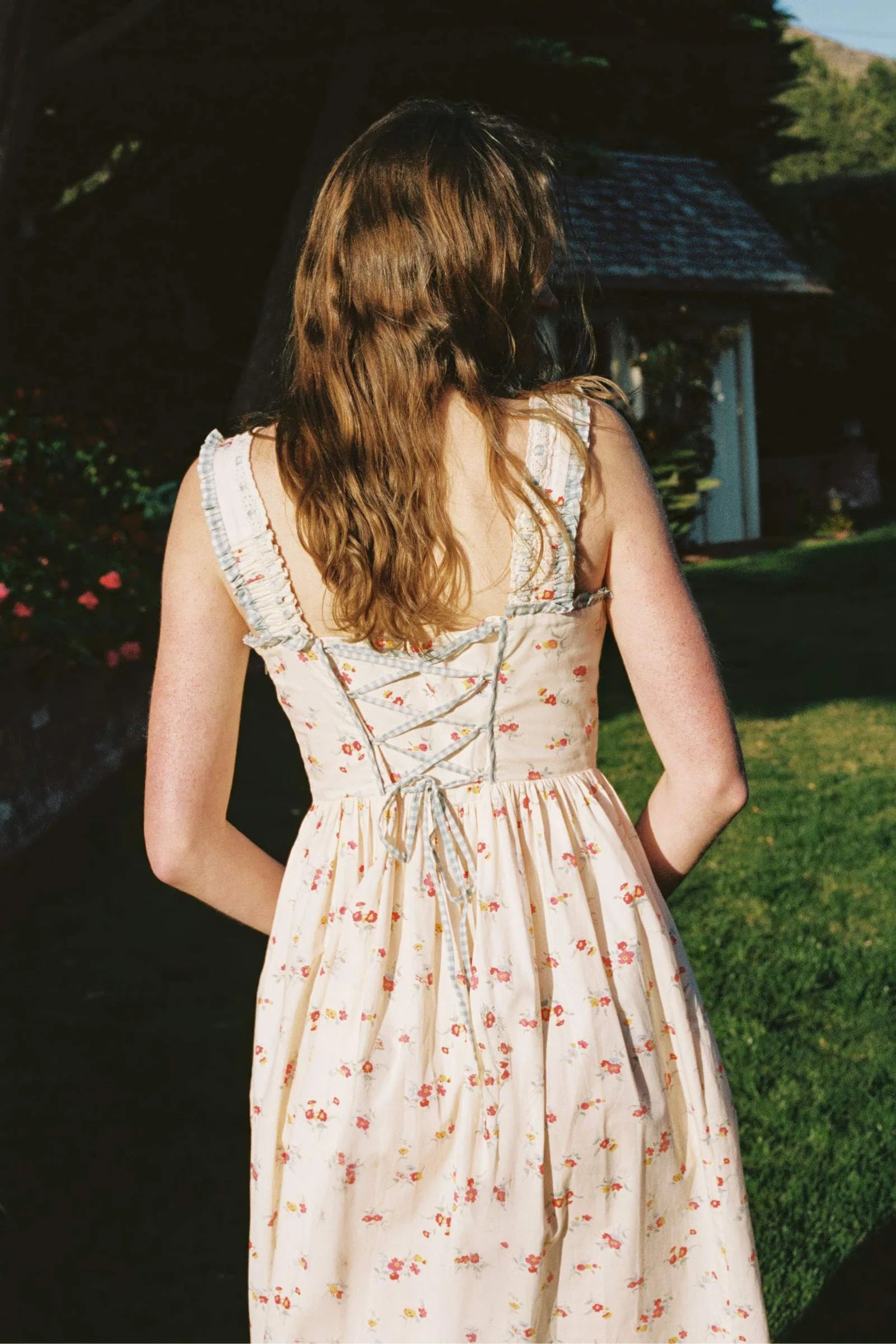 Inspired by Edwardian corsets, the Eliana Dress combines classic sophistication with contemporary ease. Made from 100% organic cotton, this sleeveless midi features an exaggerated wide scoop neckline adorned with contrasting eyelet trim and soft ruffles. A half-functional front button placket and subtle micro pintucks at the bust provide elegant accents, while the lace-up back creates a striking, form-fitting silhouette. 