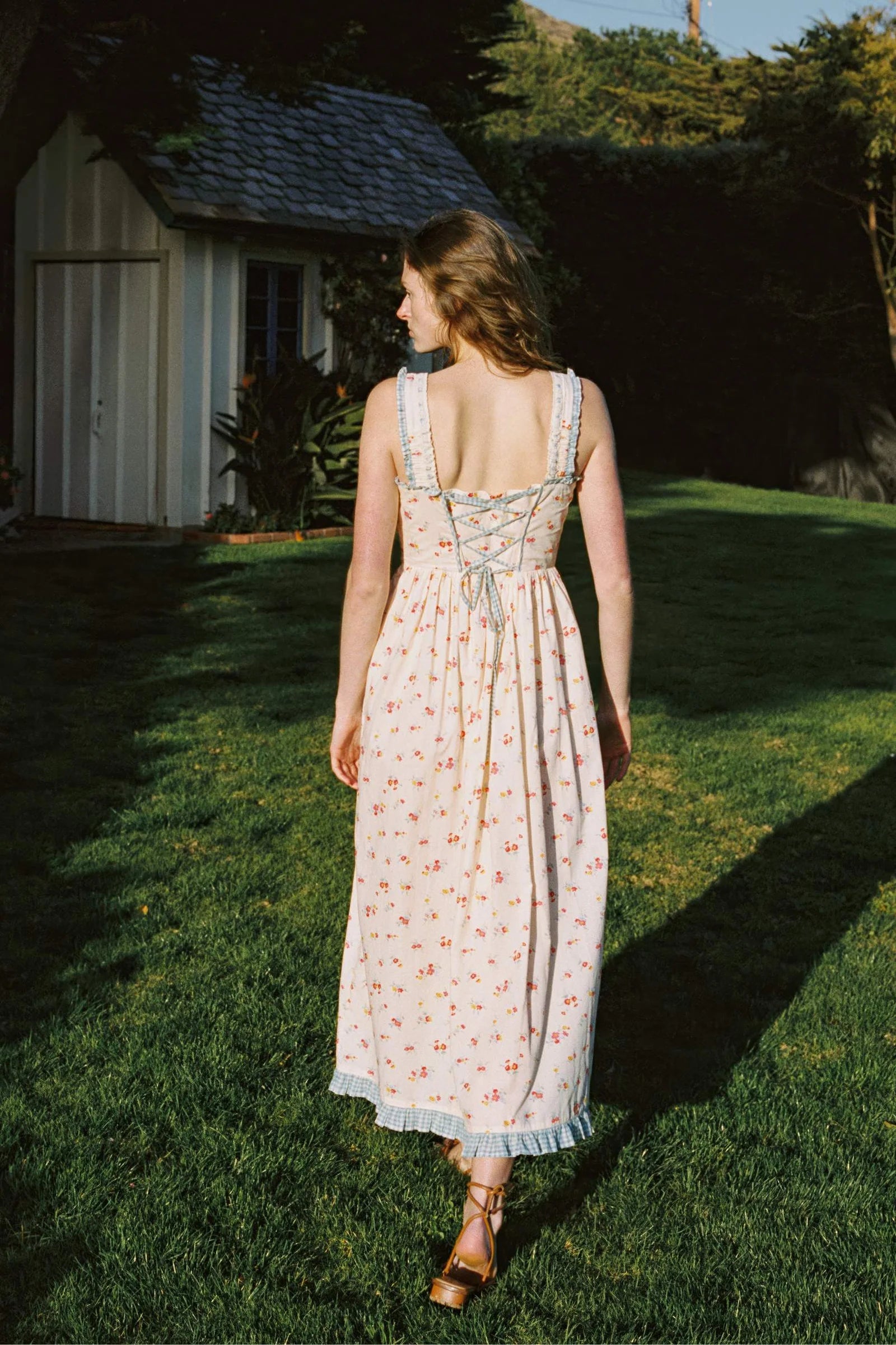 Inspired by Edwardian corsets, the Eliana Dress combines classic sophistication with contemporary ease. Made from 100% organic cotton, this sleeveless midi features an exaggerated wide scoop neckline adorned with contrasting eyelet trim and soft ruffles. A half-functional front button placket and subtle micro pintucks at the bust provide elegant accents, while the lace-up back creates a striking, form-fitting silhouette. 