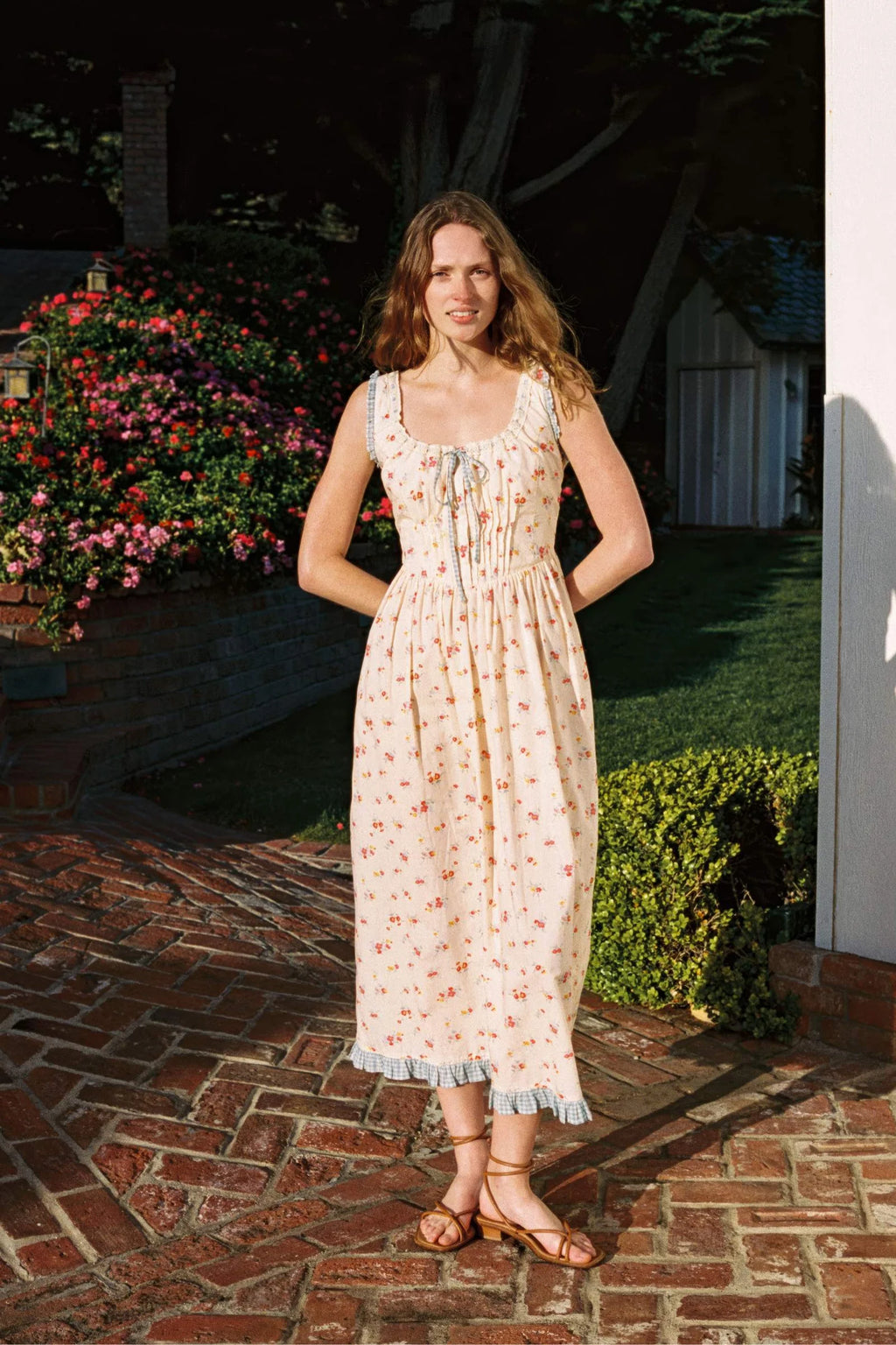 Inspired by Edwardian corsets, the Eliana Dress combines classic sophistication with contemporary ease. Made from 100% organic cotton, this sleeveless midi features an exaggerated wide scoop neckline adorned with contrasting eyelet trim and soft ruffles. A half-functional front button placket and subtle micro pintucks at the bust provide elegant accents, while the lace-up back creates a striking, form-fitting silhouette. 