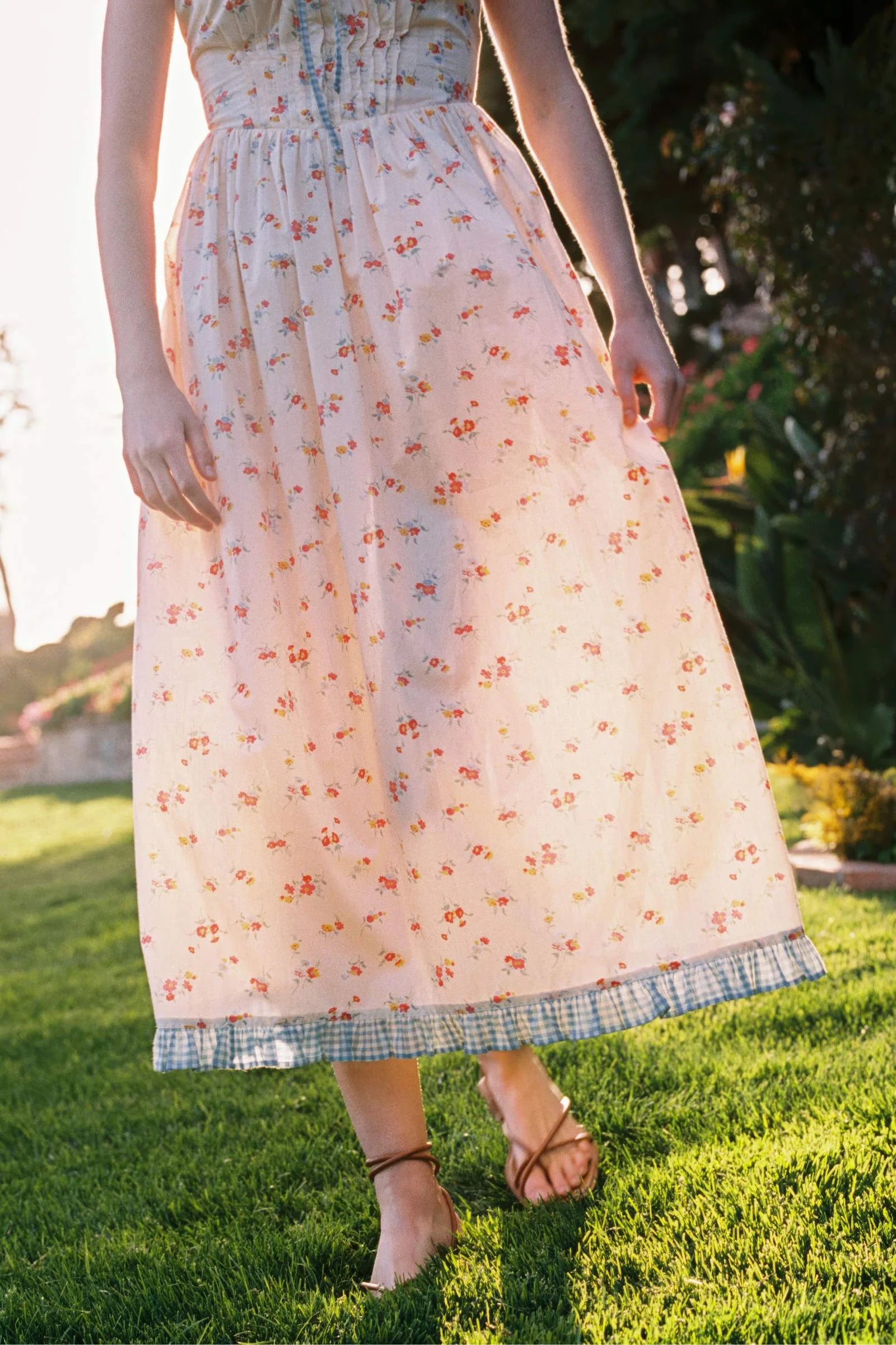 Inspired by Edwardian corsets, the Eliana Dress combines classic sophistication with contemporary ease. Made from 100% organic cotton, this sleeveless midi features an exaggerated wide scoop neckline adorned with contrasting eyelet trim and soft ruffles. A half-functional front button placket and subtle micro pintucks at the bust provide elegant accents, while the lace-up back creates a striking, form-fitting silhouette. 